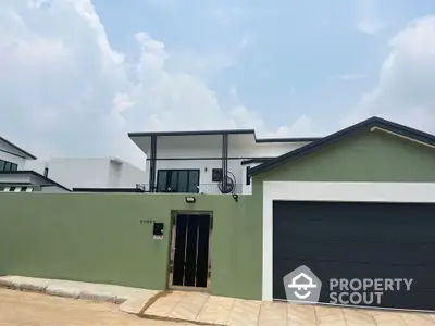 Modern green and white house with sleek garage and secure entrance