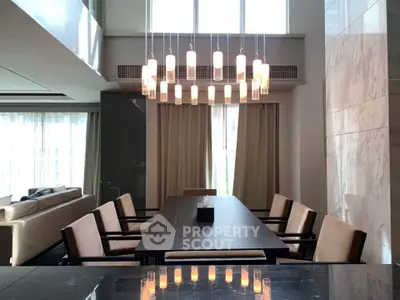 Luxurious dining area with modern chandelier and elegant seating in a spacious living room.