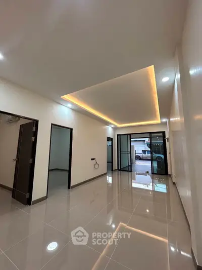 Modern interior with sleek lighting and glossy tiled floors, perfect for a stylish living space.