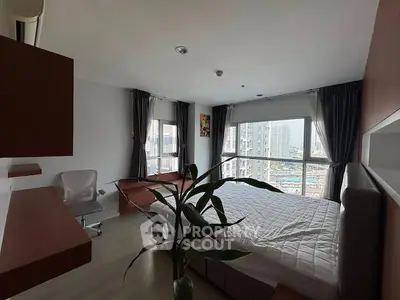 Modern bedroom with large windows offering stunning city views, featuring a cozy bed and stylish decor.