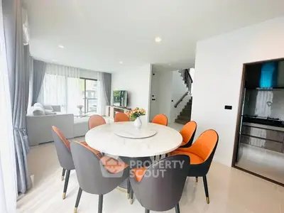 Modern dining area with elegant round table and stylish chairs in a bright open-plan living space.