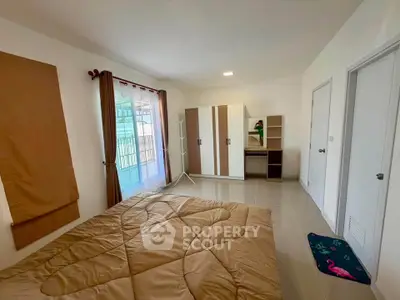 Spacious bedroom with modern wardrobe and large window for natural light.