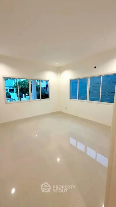 Spacious empty room with large windows and glossy tiled floor, perfect for customization.