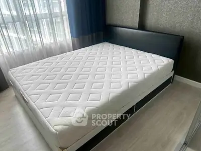 Spacious bedroom with modern design and large window for natural light.