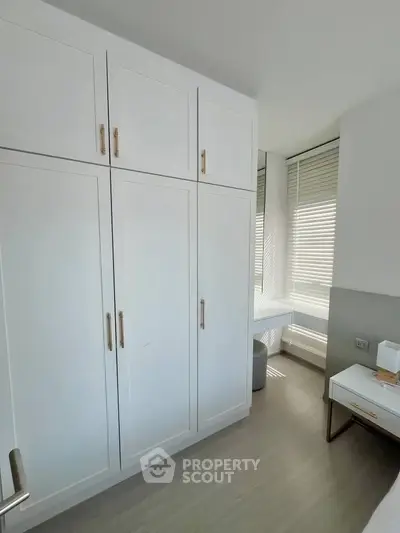 Modern bedroom with sleek white wardrobe and natural light