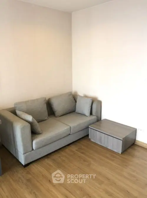 Modern living room with cozy gray sofa and wooden flooring