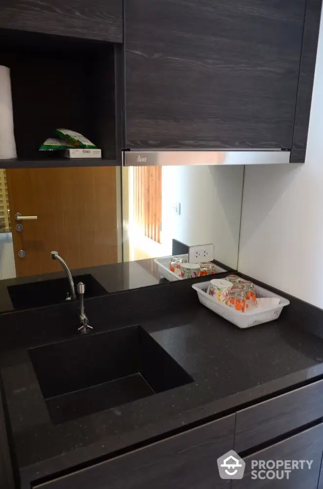 Modern kitchen with sleek black countertop and integrated sink