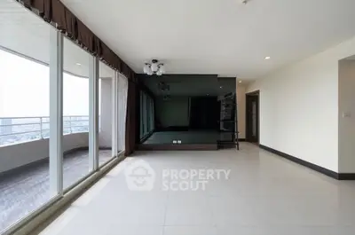 Spacious modern living room with large windows and balcony access, perfect for natural light lovers.