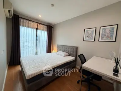 Modern bedroom with city view, featuring a stylish bed and workspace.