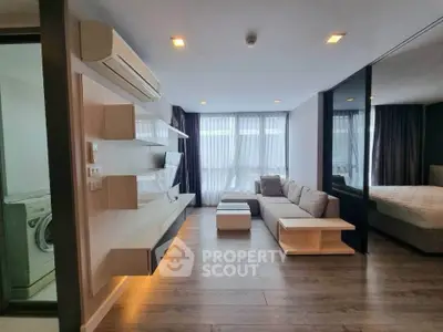 Modern living room with sleek design, featuring a cozy sofa, wall-mounted shelves, and large windows for natural light.