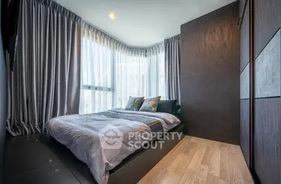 Modern bedroom with large windows and elegant curtains in a stylish apartment.