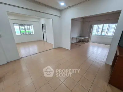 Spacious open-plan apartment with large windows and tiled flooring