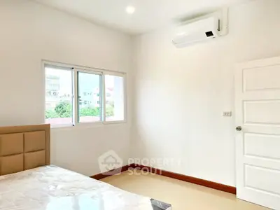 Bright bedroom with air conditioning and large window in modern apartment