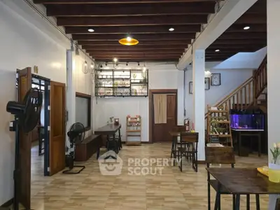 Charming open-layout living space with wooden accents and modern lighting.