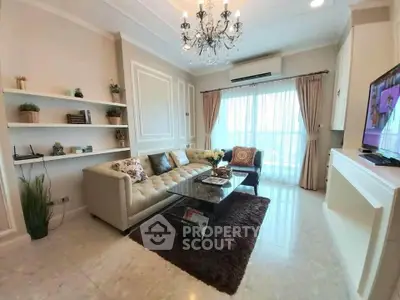 Elegant living room with chandelier, plush sofa, and large window with curtains, offering a cozy and luxurious ambiance.