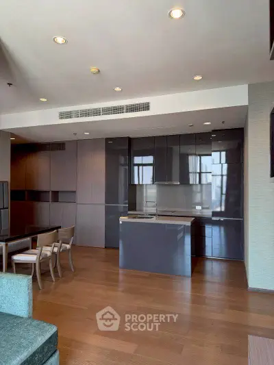 Modern open-layout kitchen with sleek cabinetry and dining area in a stylish apartment.