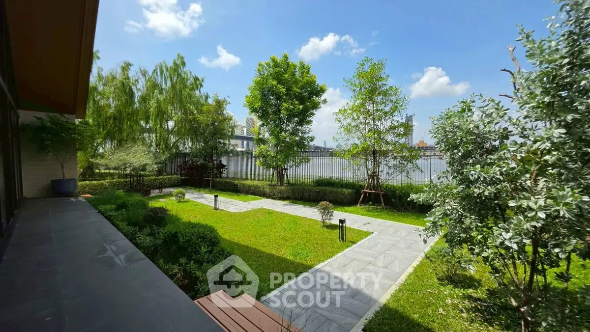 Beautiful garden view with lush greenery and clear blue sky in a serene residential setting.