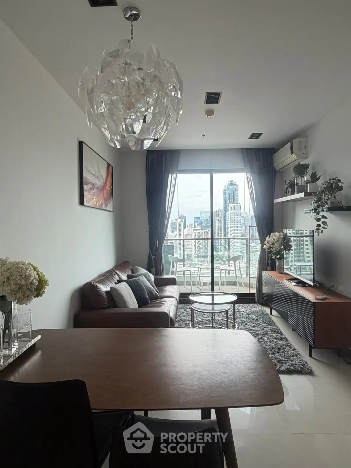 Modern living room with city view, elegant decor, and stylish furniture in a high-rise apartment.