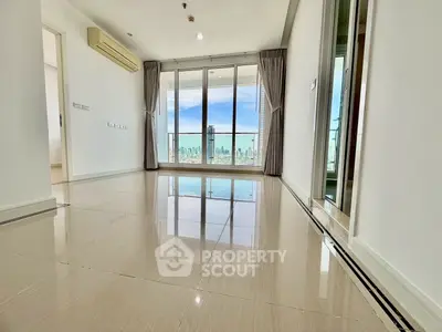 Spacious modern living room with city view and large windows in high-rise apartment.
