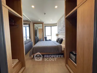 Modern bedroom with wooden accents and large mirror, featuring cozy bed and ample storage space.