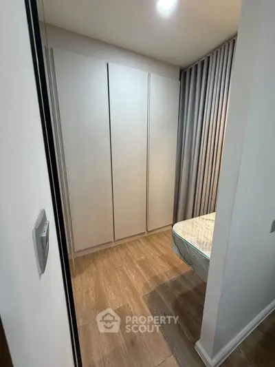 Modern bedroom with sleek wardrobe and wooden flooring, perfect for urban living.