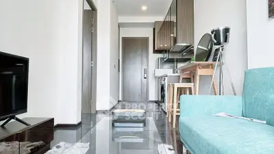 Modern living room with sleek kitchen, stylish furniture, and contemporary decor in a bright apartment.