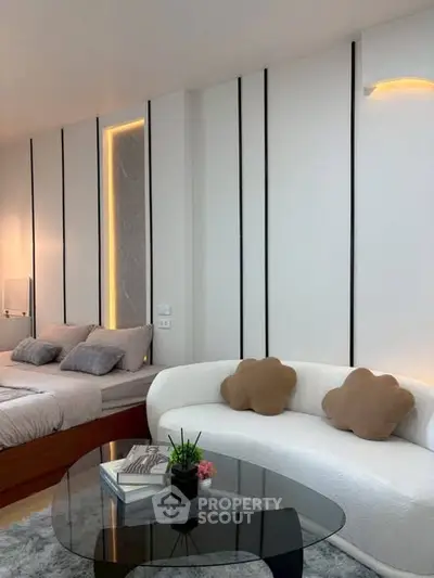 Modern bedroom with stylish decor and cozy seating area, perfect for relaxation and comfort.