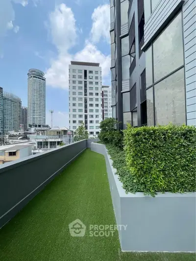 Modern urban building with lush green balcony and city skyline view