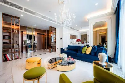 Luxurious modern living room with elegant decor and spacious design, featuring a plush blue sofa and stylish lighting.