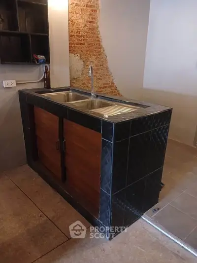 Modern kitchen with stylish sink and exposed brick wall for urban living.