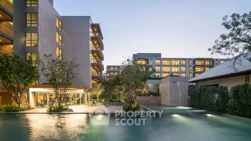 Luxurious modern apartment complex with stunning pool and lush greenery, perfect for upscale living.