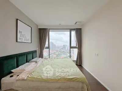 Spacious bedroom with large window offering stunning city view, perfect for relaxation and comfort.