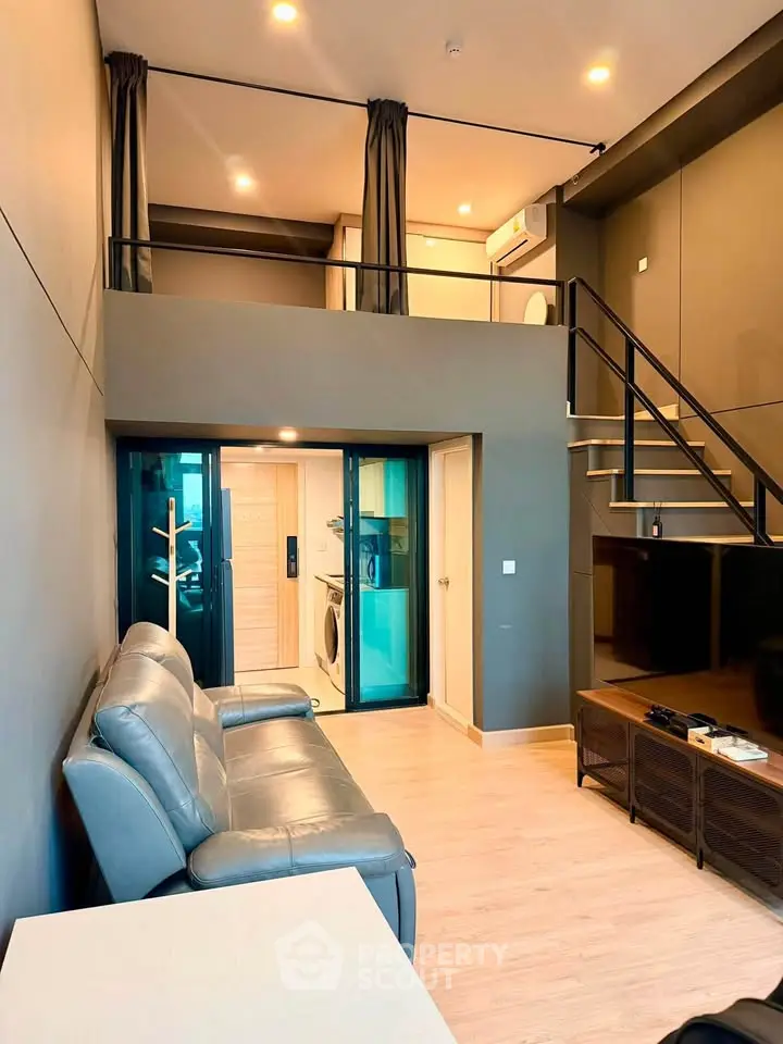 Modern loft apartment with mezzanine, stylish living area, and sleek interior design.