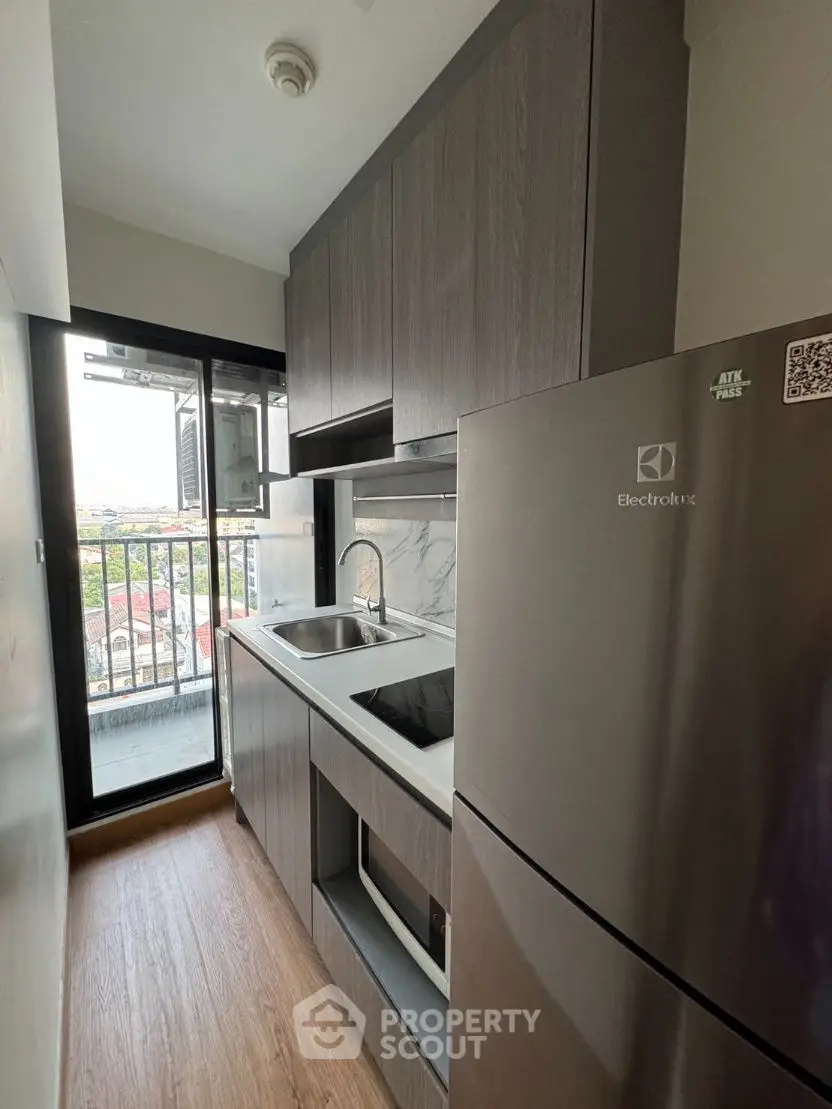 Modern compact kitchen with sleek cabinetry and balcony view