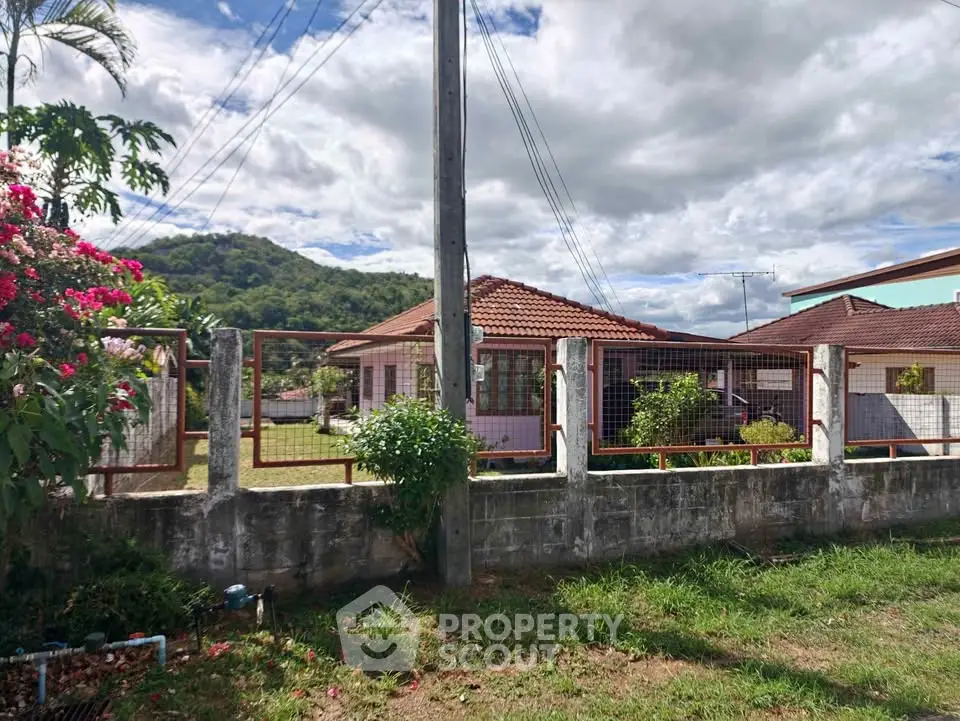 Charming suburban house with red-tiled roof and lush garden, perfect for family living.