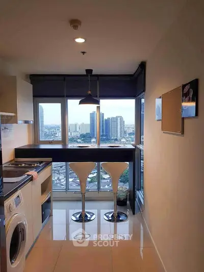 Modern kitchen with city view, featuring sleek bar seating and built-in appliances.