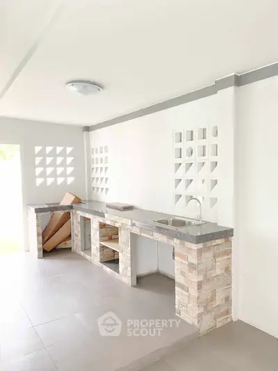 Modern minimalist kitchen with open layout and sleek stone countertops.