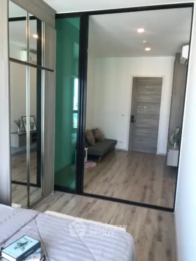 Modern bedroom with sliding glass doors and wooden flooring