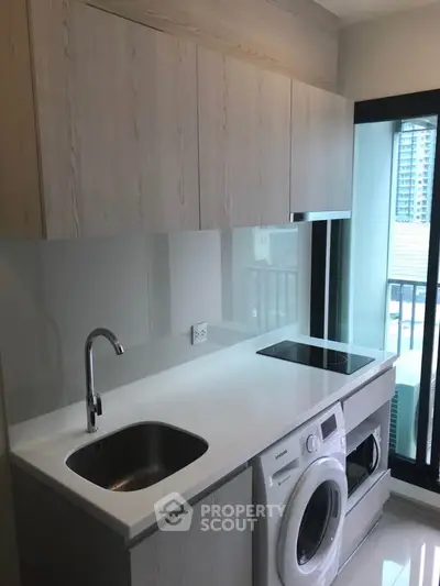 Modern kitchen with sleek cabinetry, built-in appliances, and large window view.