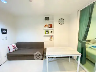 Modern living room with sleek sofa, wall shelves, and large window for natural light.