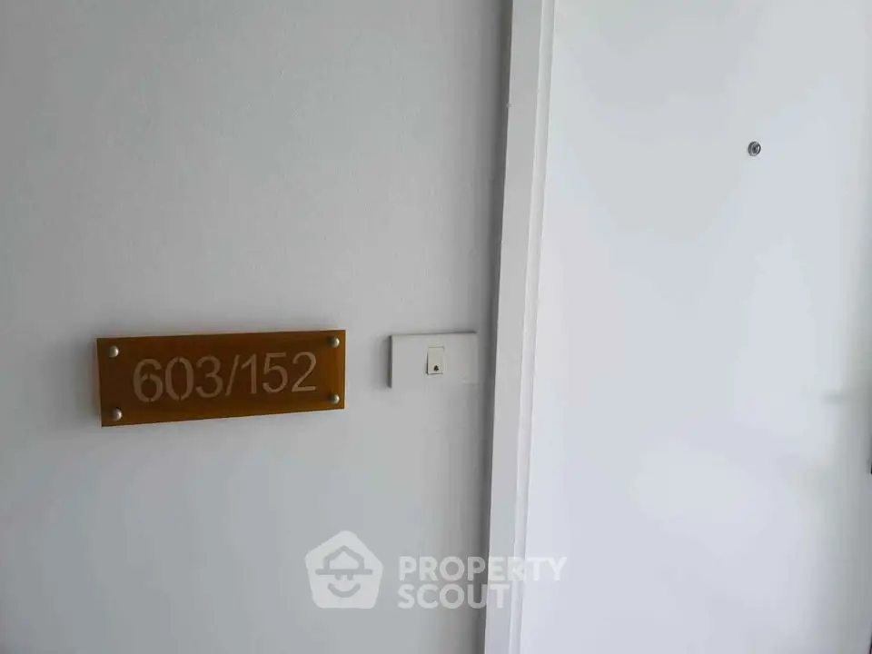 Modern apartment entrance with room number 603/152 on a sleek plaque.