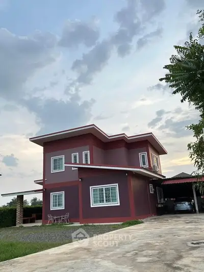 Modern two-story house with red exterior and spacious driveway