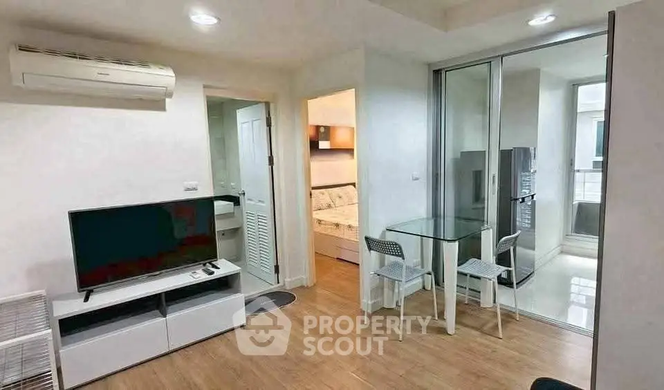 Modern apartment interior with living room, dining area, and kitchen featuring sleek design and natural light.