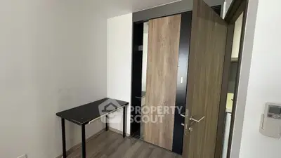 Compact study room with modern desk and sliding closet doors in a minimalist apartment.