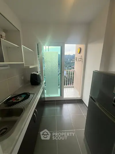 Modern kitchen with balcony view and sleek appliances in a stylish apartment.