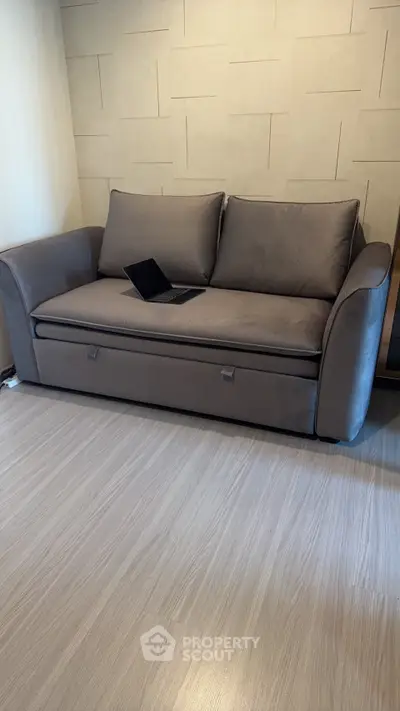 Modern living room with stylish gray sofa and sleek wooden flooring