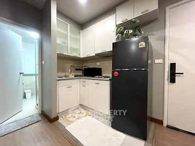 Modern kitchen with sleek cabinets and stainless steel fridge in cozy apartment
