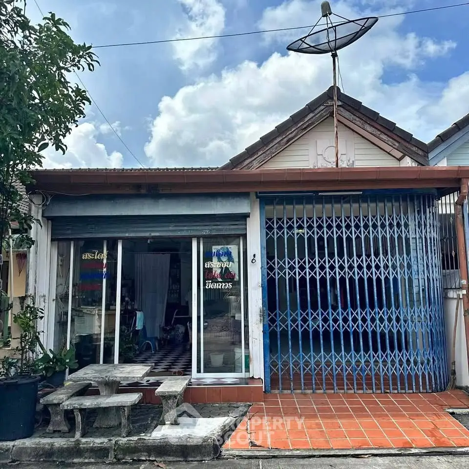 Charming single-story home with gated entrance and satellite dish, perfect for cozy living.