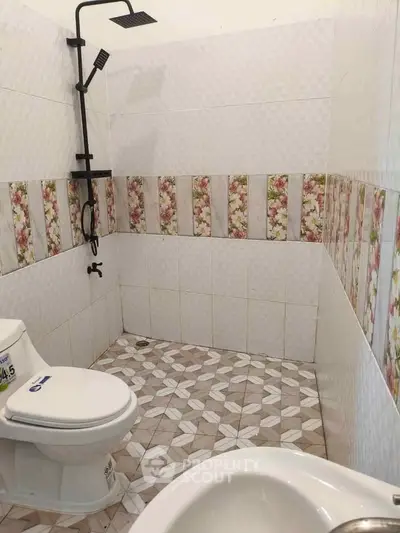 Charming bathroom with floral tile accents and modern fixtures in a cozy home.