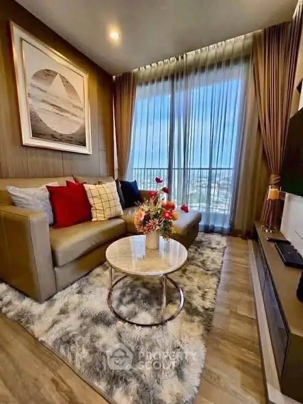 Luxurious living room with plush sofa, elegant decor, and stunning city view through large windows.